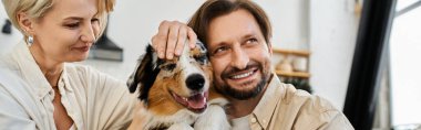 Sevgi dolu bir çift, neşeli köpekleriyle oynarken evde kaliteli vakit geçirmekten zevk alır..