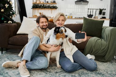 Sevgi dolu bir çift, sevimli köpekleriyle şenlikli evlerinde selfie çekmekten zevk alır..