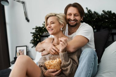 Mutlu bir çift evde birlikte vakit geçirir, patlamış mısır ve sevgi dolu anlar paylaşır..