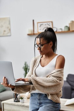 A young woman in a cozy environment studies remotely, focused on her laptop screen. clipart