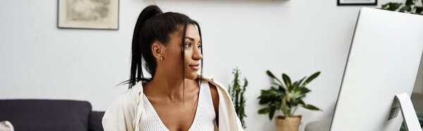 A young beautiful woman engages in remote study, focused and relaxed in her cozy home setting.