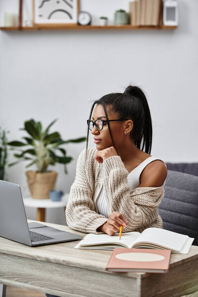 A beautiful young woman focuses on her studies at home, surrounded by plants and books.