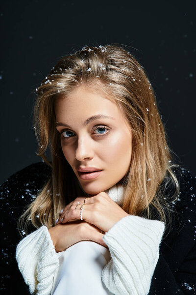 This captivating winter portrait features a woman embracing snowflakes while posing warmly.