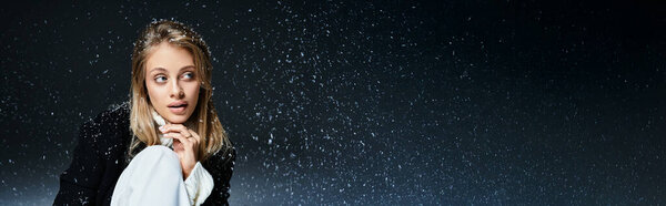 Красивая молодая женщина задумчиво смотрит, как вокруг нее танцуют снежинки в зимней сцене..