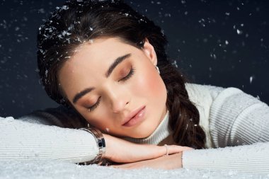 A beautiful woman rests peacefully in a snowy atmosphere, exuding tranquility and grace. clipart