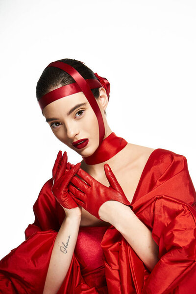 Стильная женщина в ярких красных одеждах и аксессуарах излучает уверенность и очарование.