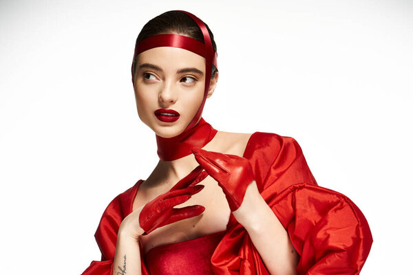 The stunning woman exudes confidence while posing gracefully in vibrant red fashion.