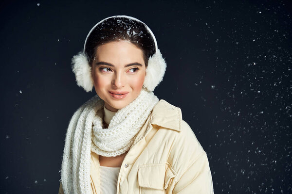 Красивая женщина в зимнем наряде излучает радость среди падающих снежинки, в то время как в комплекте тепло.