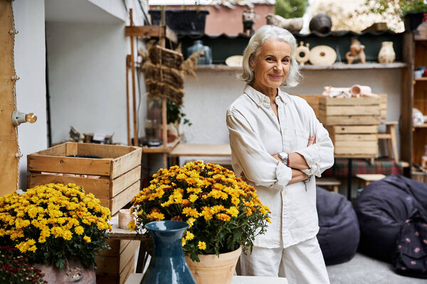 The graceful woman enjoys her time surrounded by blooming flowers and rustic decor.