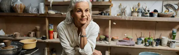 A beautiful woman finds peace in her pottery studio filled with vibrant materials.