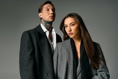 Moda ikilisi, dikkat çekici özelliklerini ve modern kıyafetlerini vurgulayarak özgüvenle ayakta duruyor..