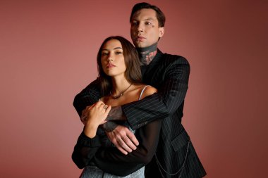 A young couple stands together, showcasing love and style in a colorful atmosphere.