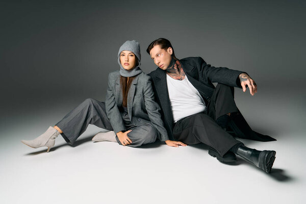 Модный дуэт сидит небрежно на гладкой поверхности, демонстрируя современные стили вместе.