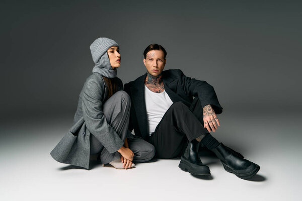 Стильная молодая пара разделяет близкий момент в минималистском пространстве, подчеркивая свою моду.