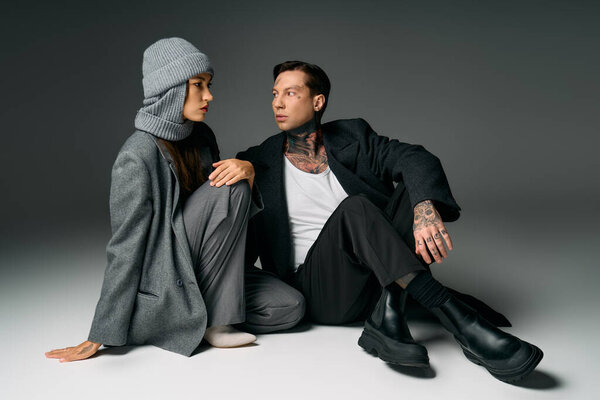 Модная пара взаимодействует в шикарных нарядах, демонстрируя современный стиль и элегантность.