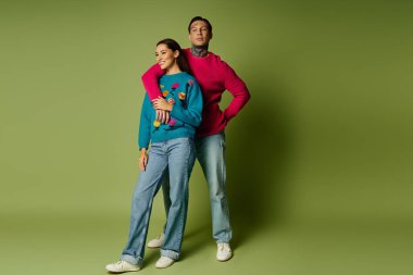 Şık bir çift, yeşil bir zemine karşı canlı bir şekilde yan yana durur..