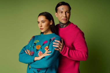 Genç bir çift canlı kazaklarını ve çarpıcı ifadelerini moda olarak sergiliyor..