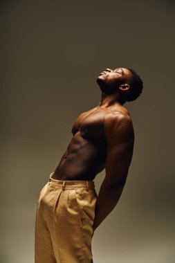 Genç, yakışıklı bir Afro-Amerikan erkeği vücudunu güçlü bir pozla sergiliyor, özgüven ve karizma yayıyor. Yaratıcı stüdyo ortamı onun eşsiz stilini ve kişiliğini ön plana çıkarıyor..