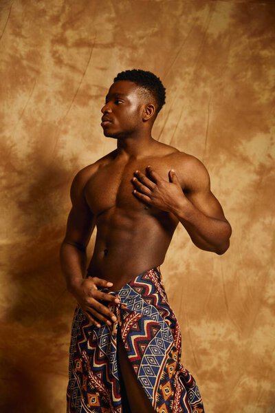 A young handsome African American man poses confidently with a captivating expression.