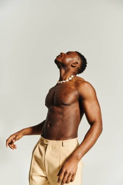 Bu çarpıcı an genç ve yakışıklı bir Afrikalı Amerikalı 'yı kendine güvenen bir duruş sergileyerek yakalıyor. Minimalist bir stüdyo ortamında zarif bir şekilde karizma yayıyor..
