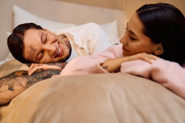 Kahkaha ve aşk havayı doldurur Bir çift rahat bir yatakta hassas bir anı paylaşır.