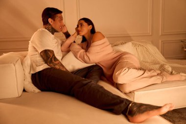 Genç bir çift kanepede birlikte hassas bir anın tadını çıkarır. Sevgi ve bağ yayarlar..