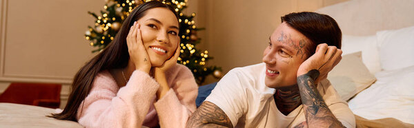 A loving couple enjoys a tender moment together by a beautifully decorated holiday tree.