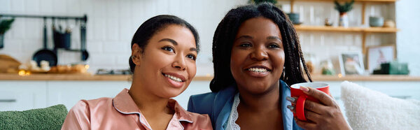 Two women enjoying each others company while relaxing on a comfortable couch at home.