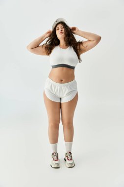 Young plus size woman poses with confidence in stylish underwear and relaxed footwear indoors clipart