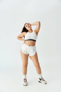 Young plus size woman showcases stylish underwear with a confident pose in a bright setting. clipart