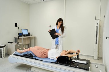 Kendini işine adamış bir kadın doktor hastanın MRI makinesinde rahat hissetmesine yardımcı olur..