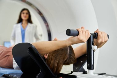Yetenekli bir doktor MRI makinesine yerleştirilmiş bir hastayı görüntüler..