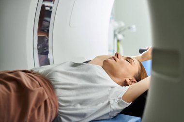 MRI makinesinde yatan bir hasta, rahatlık sağlamak için..