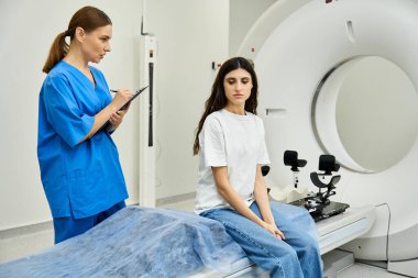 Önlüklü bir kadın doktor ayrıntıları kaydederken, modern bir hastanede hasta MRI testini bekliyor..