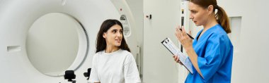 Bir kadın doktor, bir sağlık merkezinde MRI çekilmeden önce hastasına güvence veriyor..