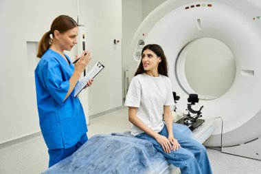 Kadın doktor, hastane ortamındaki MRI taramasından önce hastaya rehberlik eder..