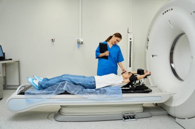 Laboratuvar önlüğü giymiş yetenekli bir doktor MRI makinesinde yalan söyleyen bir hastaya destek olur..