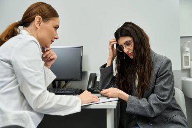 Doktor, profesyonel bir klinikte hastaların sağlığını inceler ve jinekolojik sorunları tartışır.
