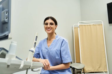 Bilge bir jinekolog modern bir klinikte hasta danışmanlığına hazırlanırken gülümser..