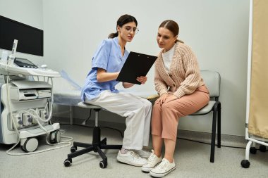 Doctor explains diagnostic results to female patient in a private clinic consultation room. clipart