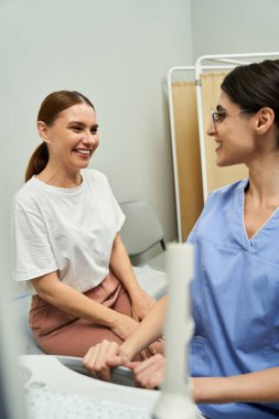Jinekolog çağdaş bir klinikte kadın bir hastanın sağlığını tartışıyor..