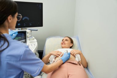Bir jinekolog, çağdaş bir klinikte kadın bir hastaya tıbbi muayene uygular..