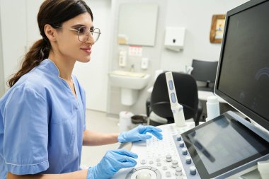 Jinekolog kadın sağlığı konusunda uzmanlaşmış modern bir klinikte ultrason yapıyor..