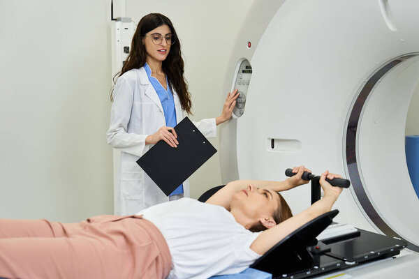 A woman in a lab coat guides a patient undergoing an MRI procedure in a hospital setting.