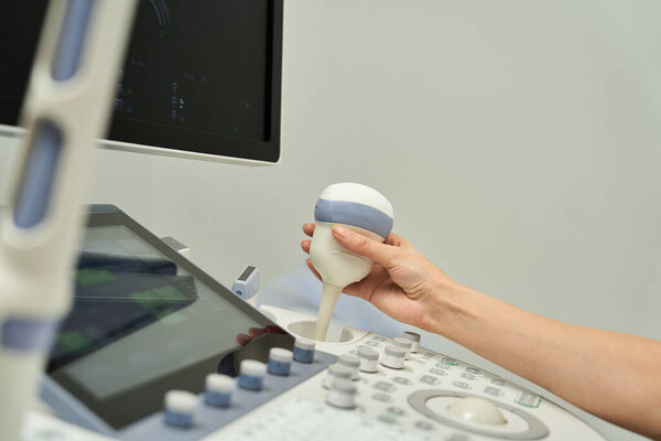 A gynecologist uses ultrasound equipment to assess female health in a contemporary clinic.
