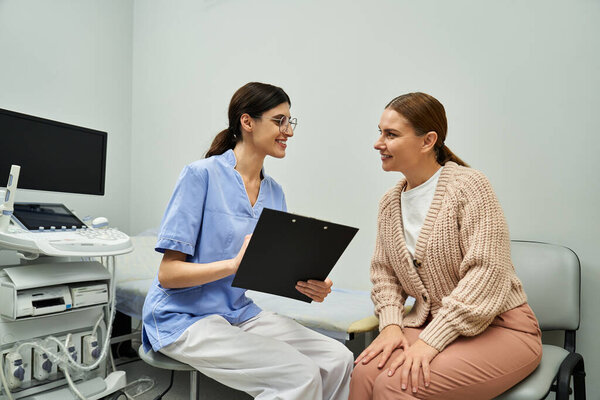 A gynecologist discusses diagnostic results with a female patient in a contemporary clinic.