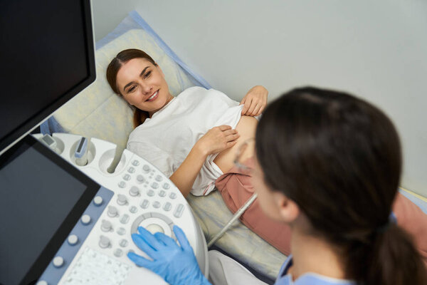 A professional gynecologist performs an examination on a female patient to ensure optimal health.