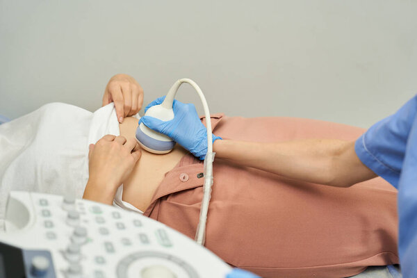 Dedicated gynecologist conducts an ultrasound checkup for a female patient, ensuring health.