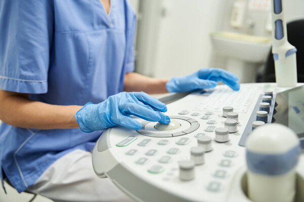 Professional examining ultrasound equipment in a clinic focused on female health care.