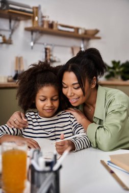 A mother and her daughter bond over a fun activity in a cozy, modern space. clipart